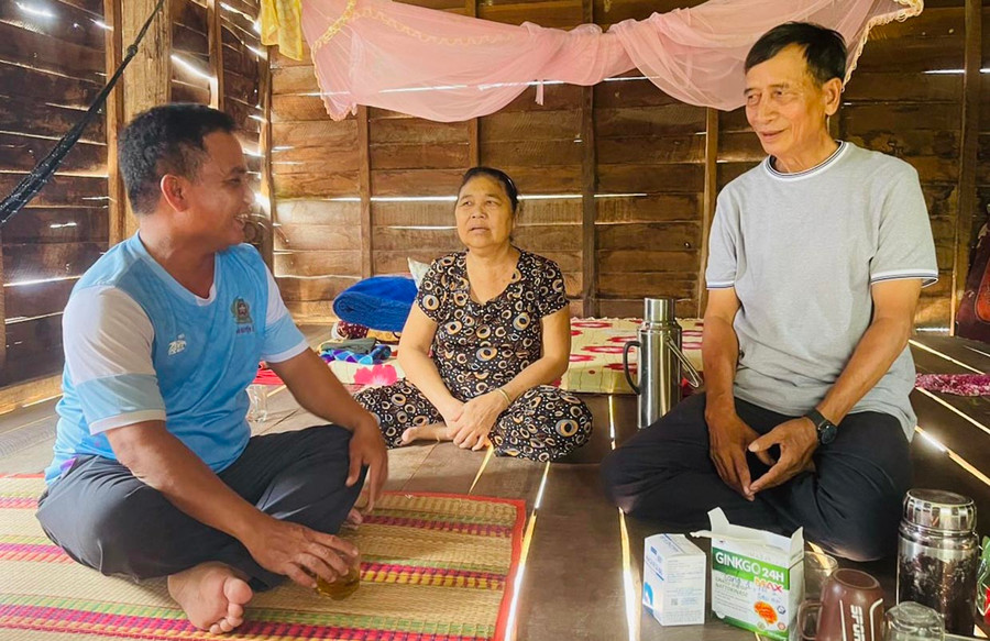 Ông Ksor Krok (bìa phải) trò chuyện cùng cán bộ Công an xã về tình hình an ninh trật tự địa phương. Ảnh: V.C