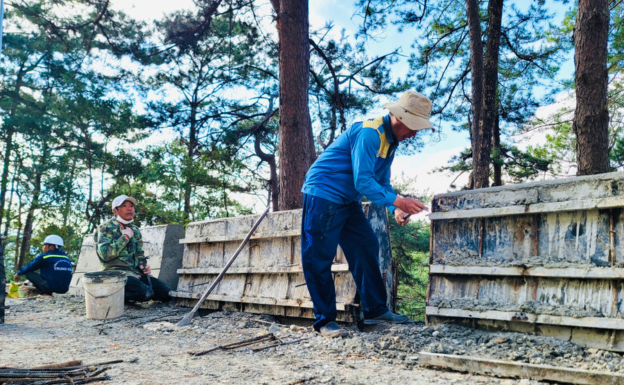 Nhóm công nhân đang hoàn thiện phần tấm chắn bê tông.