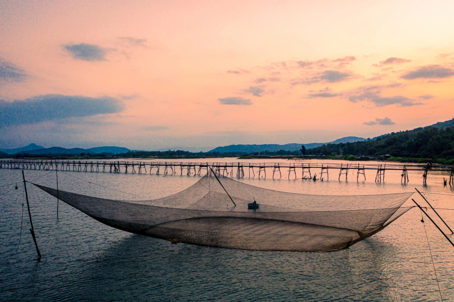 Điều tạo nên vẻ đẹp nơi đây không chỉ bởi sự mộc mạc, đơn sơ của cây cầu, mà còn do khung cảnh thiên nhiên xung quanh, với mặt nước mênh mông trong vắt, những rặng cây phi lao xanh rì và cuộc sống mưu sinh của người dân địa phương. Ảnh: BÙI VĂN HẢI Điều tạo nên vẻ đẹp nơi đây không chỉ bởi sự mộc mạc, đơn sơ của cây cầu, mà còn do khung cảnh thiên nhiên xung quanh, với mặt nước mênh mông trong vắt, những rặng cây phi lao xanh rì và cuộc sống mưu sinh của người dân địa phương. Ảnh: BÙI VĂN HẢI