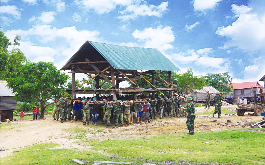 Cán bộ, chiến sĩ Quân đoàn 3 giúp người dân huyện Phú Thiện di dời nhà ở. Ảnh: Vĩnh Hoàng