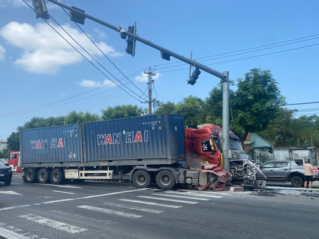 Xe container mất lái, lao vào trụ đèn giao thông khiến 2 người bị thương