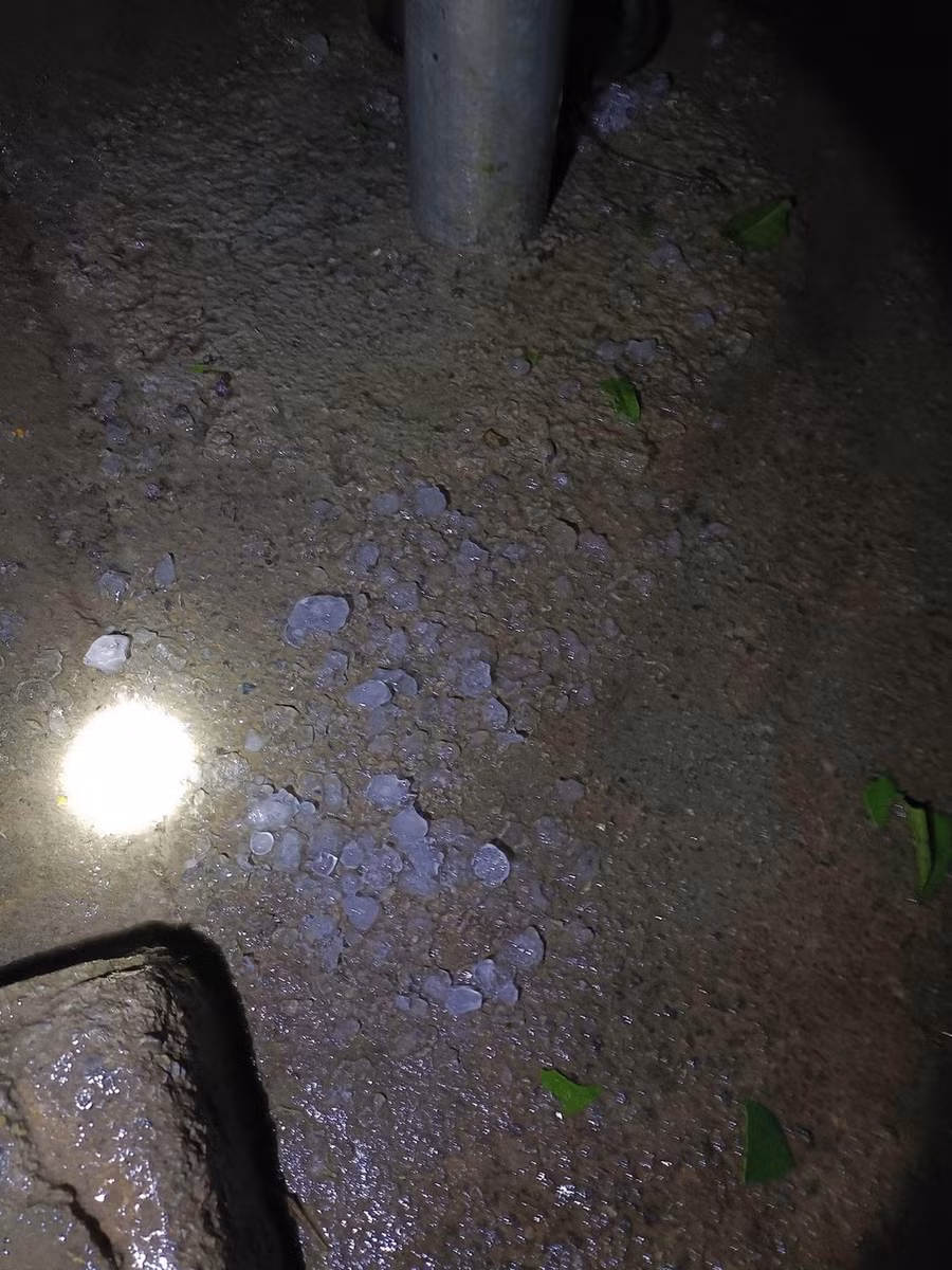 Nghe tiếng động lớn trên mái nhà, người dân ở khu vực đèo Bông Lau (Tràng Định - Lạng Sơn) cầm đèn ra soi, phát hiện mưa đá xuống cả thảm dày, đêm 21-4. Ảnh: TRƯƠNG MAI