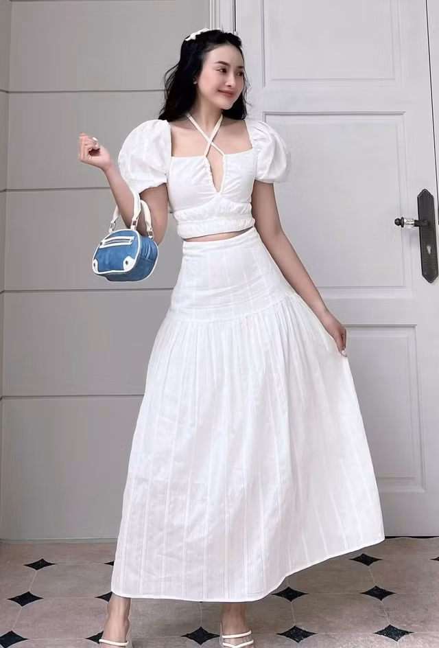 Tiện đi chơi mà cũng đẹp đi tiệc chính là sự kết hợp của áo tay phồng crop top và chân váy midi dài thướt tha. Muốn hack tuổi, tăng sự dễ thương trong sáng thì nàng nên chọn các set đồ màu trắng tinh khôi và hoàn thiện với ruy băng nơ cài tóc