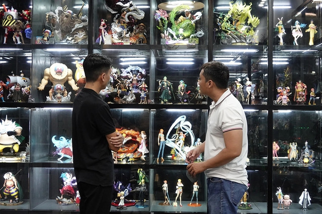 Anh Trọng (trái) giới thiệu những mô hình có giá trị từ vài trăm ngàn đến vài chục triệu đồng