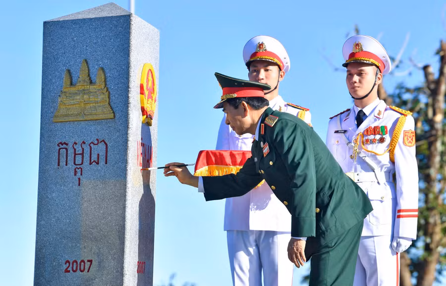 Đại tướng Phan Văn Giang tô son cột mốc chủ quyền. Ảnh: TUẤN HUY