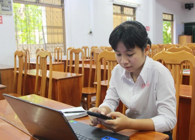 Em Nguyễn Xuân Phương Ngân, học sinh lớp 12A6, Trường THPT Lý Tự Trọng, thành phố Nha Trang, tỉnh Khánh Hòa, kiểm tra các tính năng của Marinet trên điện thoại. (Ảnh: Phan Sáu/TTXVN)