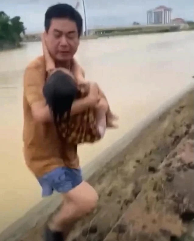 Khoảnh khắc ông Nhật ôm cháu bé lên bờ để sơ cấp cứu Khoảnh khắc ông Nhật ôm cháu bé lên bờ để sơ cấp cứu