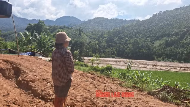 Chị Lục Thị Xim đứng nhìn về phía núi mong chờ một tia hy vọng có một phép màu. Mẹ và bố dượng cùng cháu của chị Xim bị đất vùi lấp. Hiện đã tìm thấy thi thể của bố dượng, còn mẹ chị Xim vẫn đang mất tích - Ảnh: Văn Duẩn