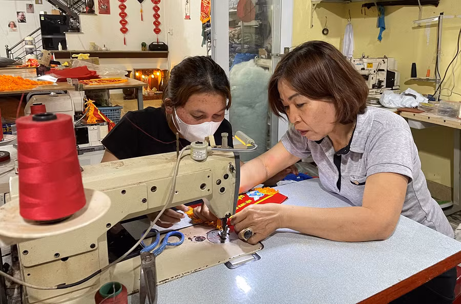 Bà Võ Thị Thu Hà (bìa phải) tỉ mỉ hướng dẫn chị H'Blanh từng đường may. Ảnh: P.D
