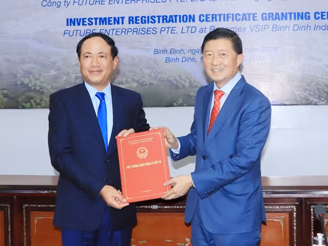 Chủ tịch UBND tỉnh Bình Định Phạm Anh Tuấn (bìa trái) đã trao giấy chứng nhận đăng ký đầu tư dự án cho ông Tan Wang Cheow. Ảnh: Thùy Trang