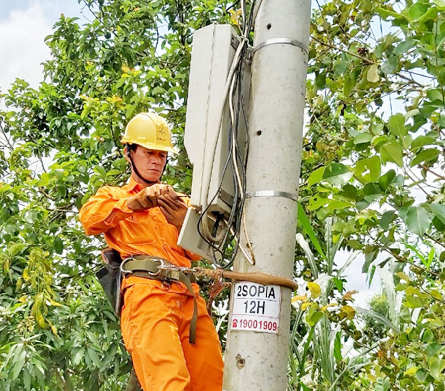 Anh Trần Xuân Thành kiểm tra công tơ điện của khách hàng. Ảnh: Công Hiền