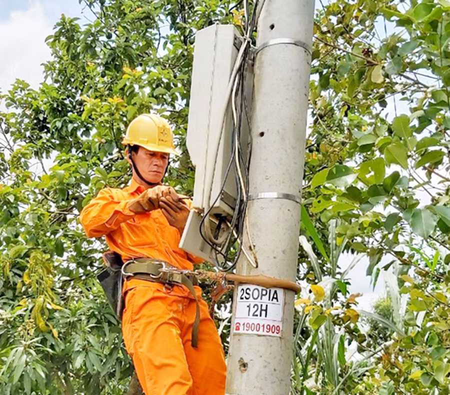 Anh Trần Xuân Thành kiểm tra công tơ điện của khách hàng. Ảnh: Công Hiền