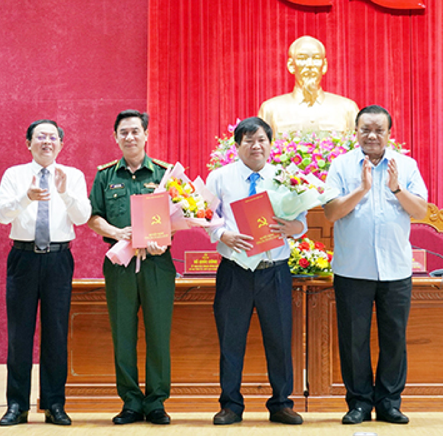 Bí thư Tỉnh ủy Bình Định Hồ Quốc Dũng (bìa trái) và Phó Bí thư Thường trực Tỉnh ủy Lê Kim Toàn (bìa phải) trao Quyết định của Ban Bí thư cho đại tá Nguyễn Văn Lĩnh và ông Trần Văn Phúc tham gia Ban Chấp hành Đảng bộ tỉnh khóa XX.