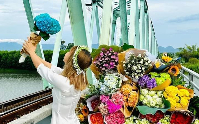 Xe hoa xuống phố mùa thu - Ảnh 2. Nguyễn Thị Minh Dân (ở xã Bình Chánh, H.Bình Sơn, Quảng Ngãi) chọn cầu xe lửa làm địa điểm lưu lại khoảnh khắc đẹp cùng xe hoa trong dịp Quốc khánh 2.9. Ảnh: ĐỨC MINH