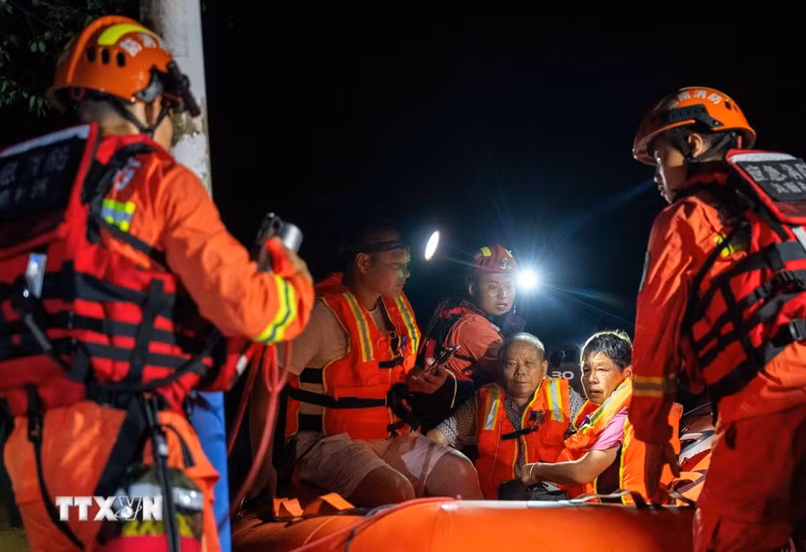 Lực lượng cứu hộ sơ tán người dân tại khu vực bị ảnh hưởng sau sự cố vỡ đê sông Juanshui ở huyện Tương Đàm, tỉnh Hồ Nam, Trung Quốc, ngày 29/7/2024. (Ảnh: THX/TTXVN)