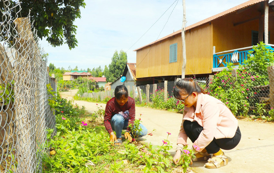 Phụ nữ làng Kươk (xã Sró, huyện Kông Chro) chăm sóc con đường hoa. Ảnh: Ngọc Minh