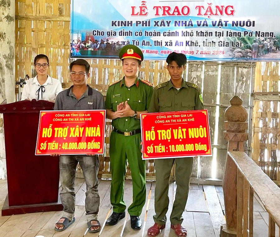 Thượng tá Nguyễn Thành Huy-Trưởng Công an thị xã An Khê trao kinh phí và vật nuôi hỗ trợ gia đình có hoàn cảnh khó khăn ở làng Pơ Nang, xã Tú An. Ảnh: N.M