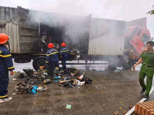 Lực lượng chức năng khống chế đám cháy bùng phát trên thùng xe tải chở bưu phẩm chuyển phát nhanh. Ảnh: Công an Quảng Trị