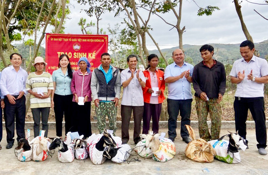 Đại diện Ủy ban MTTQ Việt Nam tỉnh và huyện Krông Pa trao sinh kế cho các hộ nghèo người dân tộc thiểu số ở xã Đất Bằng. Ảnh: L.N