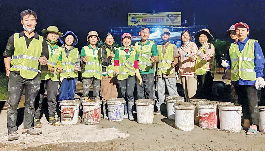 Anh Lê Tuấn Thành (thứ 7 từ trái sang) tham gia hoạt động vá đường. Ảnh: P.L