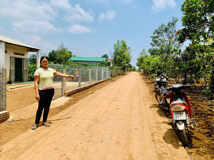 Chị Rơ Châm Úk (làng Kép, xã Ia Phí) bên con đường bê tông mà gia đình đã hiến đất để mở rộng. Ảnh: N.H