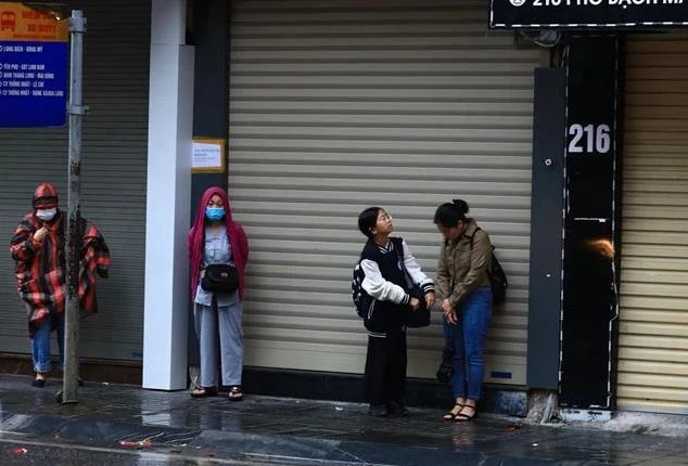 Người dân cảm nhận rõ cái lạnh trong thời tiết mưa, rét sáng. (Ảnh: Hoàng Hiếu/TTXVN)