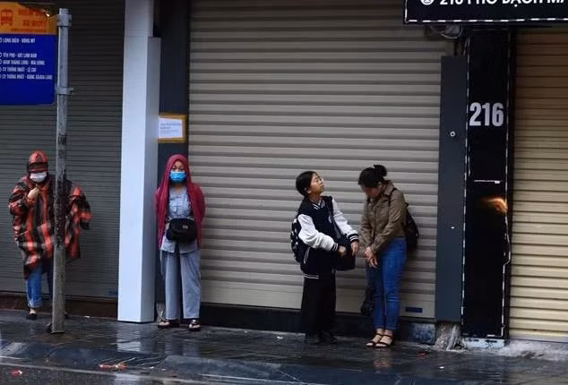 Người dân cảm nhận rõ cái lạnh trong thời tiết mưa, rét sáng. (Ảnh: Hoàng Hiếu/TTXVN)