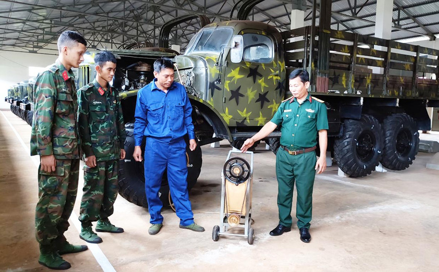 Thiếu tá Đặng Bá Hiền (bìa phải) hướng dẫn đồng nghiệp sử dụng thiết bị bơm hút dầu động cơ ô tô. Ảnh: V.H Thiếu tá Đặng Bá Hiền (bìa phải) hướng dẫn đồng nghiệp sử dụng thiết bị bơm hút dầu động cơ ô tô. Ảnh: V.H
