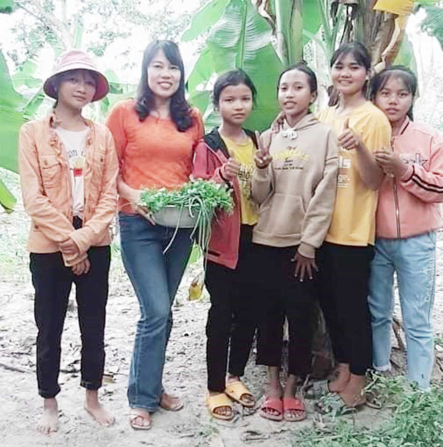 Tác giả (thứ 2 từ trái sang) trong một lần về làng thăm học sinh. Ảnh: Mai Hương