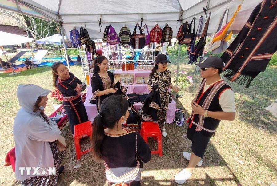 Du khách hào hứng với các sản phẩm thổ cẩm bản địa tại Kon Tum. (Ảnh: Dư Toán/TTXVN)