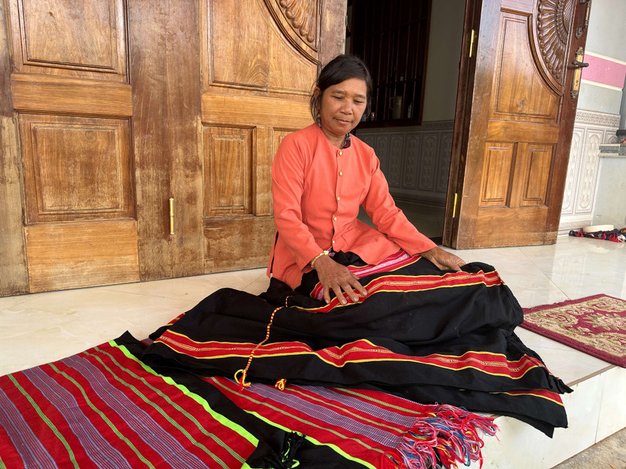 Bà Y Két khoe những sản phẩm thổ cẩm do chính tay bà dệt. Ảnh: VT