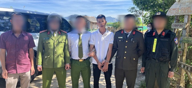 Trần Đông Lập (áo trắng), một trong hai nghi phạm cướp ngân hàng ở Quảng Nam, bị bắt giữ. Ảnh: CA