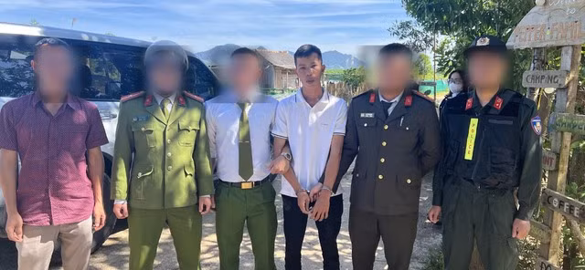 Trần Đông Lập (áo trắng), một trong hai nghi phạm cướp ngân hàng ở Quảng Nam, bị bắt giữ. Ảnh: CA