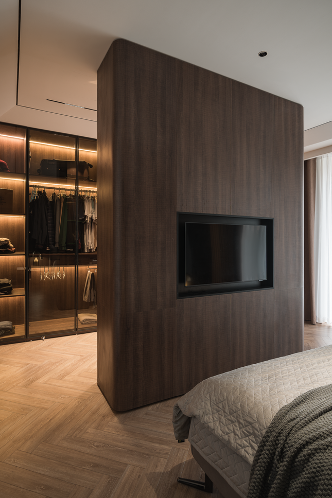 Hệ tủ hai mặt tách khu vực ngủ và thay đồ, với mặt ngoài là hệ vách ngăn và tivi.