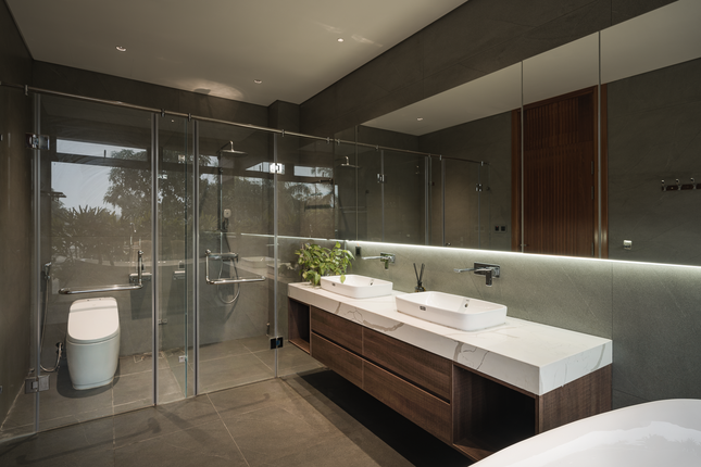 Khu vực rửa tay, tắm và vệ sinh được ngăn cách bởi tấm kính trong suốt.