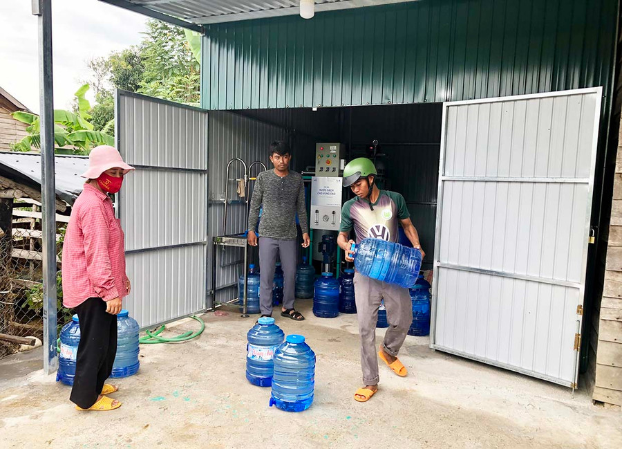Người dân mua nước từ dự án nước sạch vùng cao về dùng. Ảnh: Lê Nam