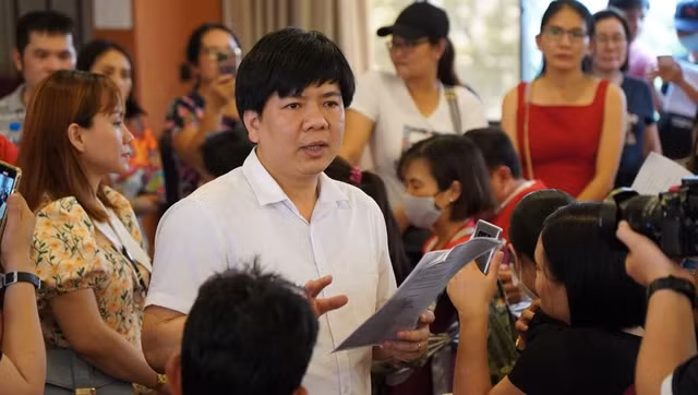 Ông Nguyễn Ngọc Thủy đọc lộ trình hoàn học phí trước hàng trăm phụ huynh TP.HCM tại cuộc họp cuối cùng ở miền Nam vào tháng 4.2023. ẢNH: NGUYỄN ANH