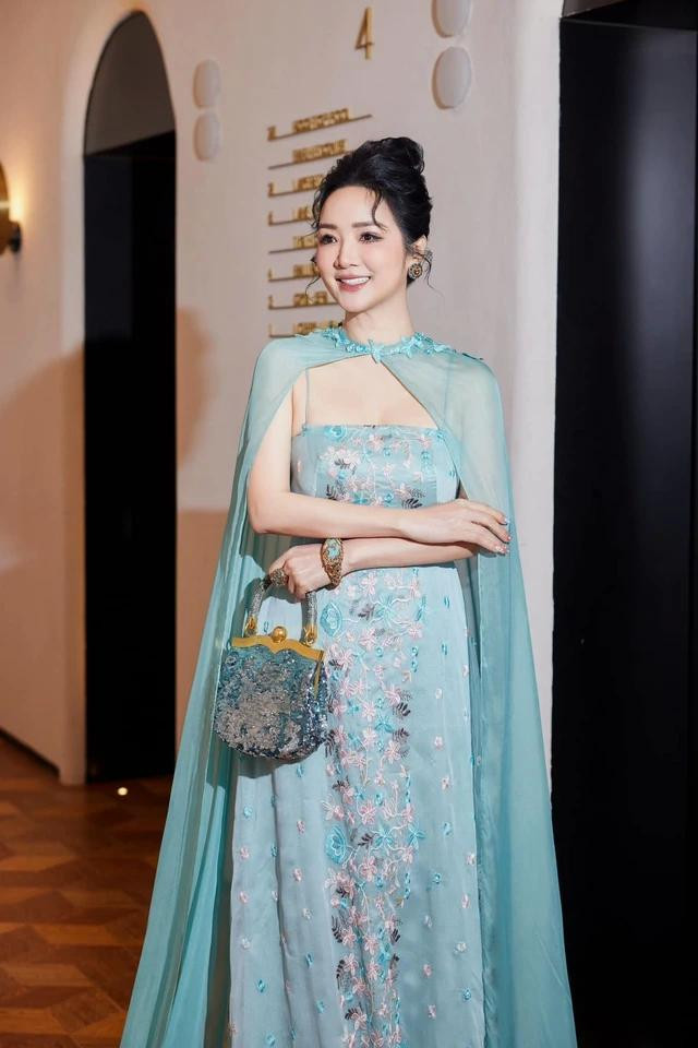 Chiếc đầm thiết kế tông xanh ngọc trang trí bởi các đường thêu tinh tế kết hợp với chiếc túi xách và trang sức cùng màu khiến người đẹp không chỉ quý phái, sang trọng mà còn rất trẻ trung và quyến rũ. Ảnh FACEBOOK NV