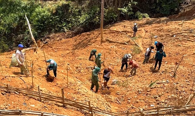 Bộ đội giúp dân san ủi mặt bằng trồng rau sạch. Ảnh: Nam Thịnh