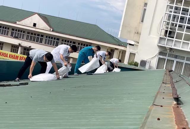 Nhân viên y tế dùng bao cát gia cố các mái tôn. Ảnh: Bệnh viện cung cấp
