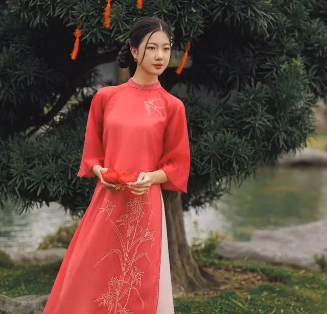 Mặc cho ngoài kia có vô vàn màu sắc rực rỡ thì hồng đào vẫn luôn là gam màu "ruột", có mặt trong tủ quần áo đón xuân của biết bao chị em. Đây là sắc màu đại diện cho sự trẻ trung, pha trộn thêm nét thơ ngây trong trẻo. Điểm thêm hình thêu trước ngực đậm phong vị truyền thống, trên nền tơ mềm bay bổng, kiêu sa, tà áo dài này chính là lựa chọn tuyệt vời cho ngày tụ họp cùng bạn bè hay gặp gỡ người thân Mặc cho ngoài kia có vô vàn màu sắc rực rỡ thì hồng đào vẫn luôn là gam màu "ruột", có mặt trong tủ quần áo đón xuân của biết bao chị em. Đây là sắc màu đại diện cho sự trẻ trung, pha trộn thêm nét thơ ngây trong trẻo. Điểm thêm hình thêu trước ngực đậm phong vị truyền thống, trên nền tơ mềm bay bổng, kiêu sa, tà áo dài này chính là lựa chọn tuyệt vời cho ngày tụ họp cùng bạn bè hay gặp gỡ người thân