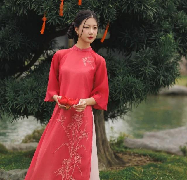 Mặc cho ngoài kia có vô vàn màu sắc rực rỡ thì hồng đào vẫn luôn là gam màu "ruột", có mặt trong tủ quần áo đón xuân của biết bao chị em. Đây là sắc màu đại diện cho sự trẻ trung, pha trộn thêm nét thơ ngây trong trẻo. Điểm thêm hình thêu trước ngực đậm phong vị truyền thống, trên nền tơ mềm bay bổng, kiêu sa, tà áo dài này chính là lựa chọn tuyệt vời cho ngày tụ họp cùng bạn bè hay gặp gỡ người thân Mặc cho ngoài kia có vô vàn màu sắc rực rỡ thì hồng đào vẫn luôn là gam màu "ruột", có mặt trong tủ quần áo đón xuân của biết bao chị em. Đây là sắc màu đại diện cho sự trẻ trung, pha trộn thêm nét thơ ngây trong trẻo. Điểm thêm hình thêu trước ngực đậm phong vị truyền thống, trên nền tơ mềm bay bổng, kiêu sa, tà áo dài này chính là lựa chọn tuyệt vời cho ngày tụ họp cùng bạn bè hay gặp gỡ người thân