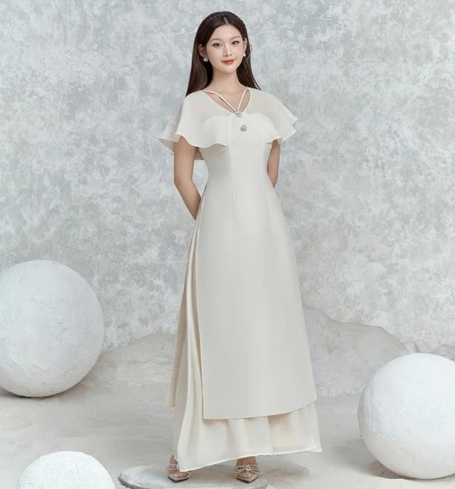 Là sự kết hợp đầy tinh tế giữa tà áo dài truyền thống và được biến tấu cùng những chi tiết hiện đại ở phần tay, vai và cổ áo dây V, điểm xuyết thêm những chi tiết đá sáng lấp lánh giữ trọn vẻ đoan trang của người phụ nữ Việt xưa, nhưng bên cạnh đó vẫn phô bày được nét cá tính, trẻ trung của quý cô hiện đại Là sự kết hợp đầy tinh tế giữa tà áo dài truyền thống và được biến tấu cùng những chi tiết hiện đại ở phần tay, vai và cổ áo dây V, điểm xuyết thêm những chi tiết đá sáng lấp lánh giữ trọn vẻ đoan trang của người phụ nữ Việt xưa, nhưng bên cạnh đó vẫn phô bày được nét cá tính, trẻ trung của quý cô hiện đại