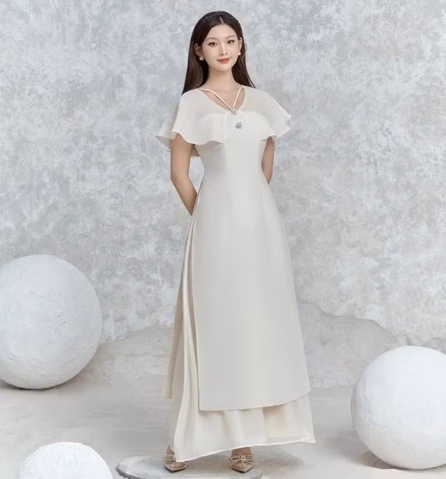 Là sự kết hợp đầy tinh tế giữa tà áo dài truyền thống và được biến tấu cùng những chi tiết hiện đại ở phần tay, vai và cổ áo dây V, điểm xuyết thêm những chi tiết đá sáng lấp lánh giữ trọn vẻ đoan trang của người phụ nữ Việt xưa, nhưng bên cạnh đó vẫn phô bày được nét cá tính, trẻ trung của quý cô hiện đại