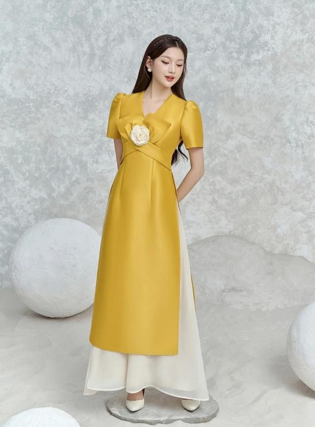 May mắn và tràn đầy sức sống với sắc vàng - gam màu không thể thiếu trong mùa xuân. Kết cấu tay ngắn cổ chữ V với đai eo cách điệu cùng hoa mai trà làm điểm nhấn nổi bật. Mẫu áo dài là sự kết hợp hài hòa giữa nét đẹp truyền thống cùng thiết kế hiện đại. Diện chiếc áo dài này, nàng sẽ trở thành tâm điểm mỗi khi xuất hiện. Được may dựng trên nền chất vải tơ mềm mại là điều khiến bộ trang phục trở nên sang trọng và quý phái hơn bao giờ hết. Đường may hai lớp chỉn chu tạo nên sự hoàn thiện và bền bỉ, giúp nàng tự tin thể hiện vẻ đẹp đích thực của mình May mắn và tràn đầy sức sống với sắc vàng - gam màu không thể thiếu trong mùa xuân. Kết cấu tay ngắn cổ chữ V với đai eo cách điệu cùng hoa mai trà làm điểm nhấn nổi bật. Mẫu áo dài là sự kết hợp hài hòa giữa nét đẹp truyền thống cùng thiết kế hiện đại. Diện chiếc áo dài này, nàng sẽ trở thành tâm điểm mỗi khi xuất hiện. Được may dựng trên nền chất vải tơ mềm mại là điều khiến bộ trang phục trở nên sang trọng và quý phái hơn bao giờ hết. Đường may hai lớp chỉn chu tạo nên sự hoàn thiện và bền bỉ, giúp nàng tự tin thể hiện vẻ đẹp đích thực của mình