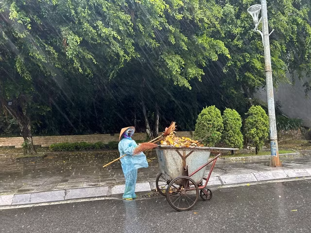 Công nhân vệ sinh làm việc dưới mưa gió