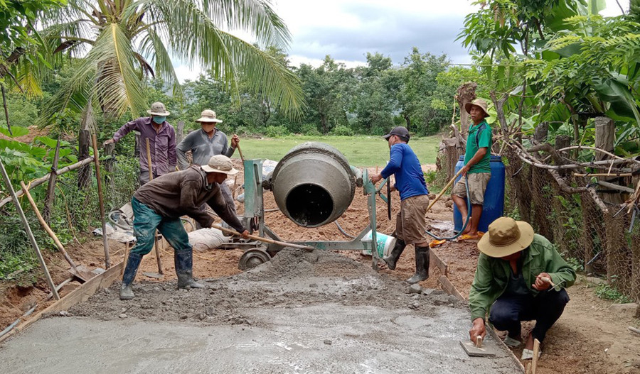 Đảng viên Chi bộ buôn Biah B chung sức làm đường bê tông đoạn nối ra khu sản xuất của người dân. Ảnh: V.C