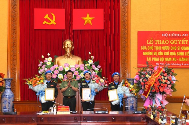Thứ trưởng Lương Tam Quang trao Quyết định của Chủ tịch nước cho 3 sỹ quan. (Nguồn: Báo Công an Nhân dân)