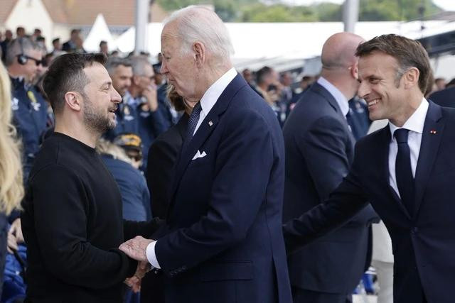 Ông Zelensky (trái) bắt tay ông Biden, với sự hiện diện của ông Macron ngày 6.6. Ông Zelensky (trái) bắt tay ông Biden, với sự hiện diện của ông Macron ngày 6.6.
