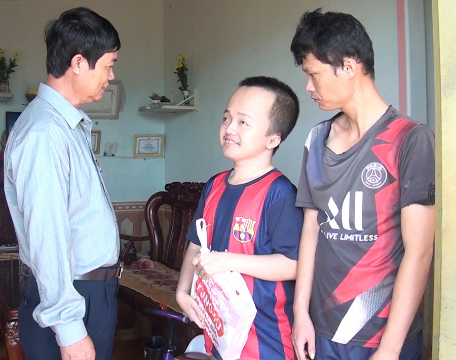 Chủ tịch Hội Nạn nhân CĐDC/dioxin huyện Chư Sê Nguyễn Xuân Thủy tặng quà cho 2 anh em Lê Bá Can và Lê Bá Toán (làng Dơ Nông Ó, xã Kông Htok). Ảnh: Nhật Hào